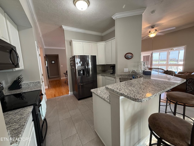 7243 Autumn View Ln, Powell, TN 37849 - kitchen with black appliances, a sink, a peninsula, a breakfast bar, and light stone counters