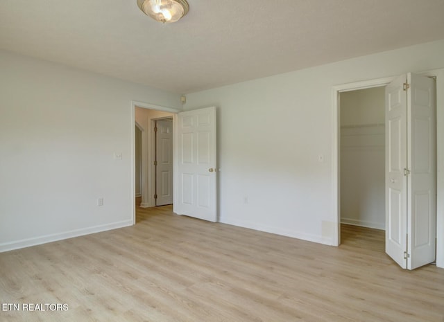 1023 Stokley Ct, Dandridge, TN 37725 - unfurnished bedroom featuring light wood-type flooring, a walk in closet, and a closet