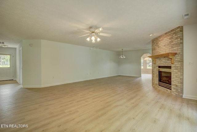 1023 Stokley Ct, Dandridge, TN 37725 - unfurnished living room with light wood-type flooring, a ceiling fan, and a fireplace