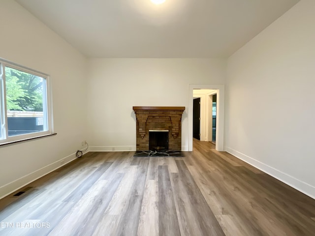 2634 Barton St, Knoxville, TN 37917 - unfurnished living room featuring a brick fireplace, wood finished floors, and baseboards