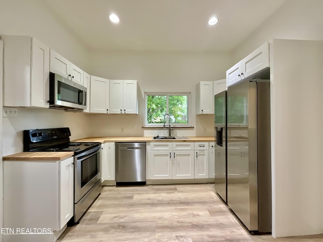 2634 Barton St, Knoxville, TN 37917 - kitchen with stainless steel appliances, butcher block counters, a sink, white cabinets, and recessed lighting