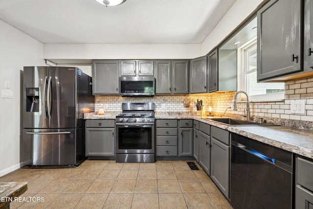 7901 Ewing Rd, Powell, TN 37849 - kitchen with appliances with stainless steel finishes, a sink, gray cabinetry, and backsplash