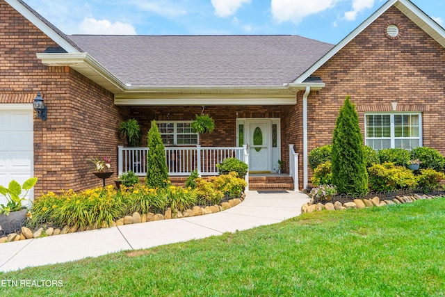 7924 Cedar Stone Ln, Powell, TN 37849 - view of exterior entry featuring brick siding, covered porch, a yard, and a shingled roof