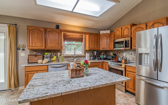4512 Clairson Dr, Knoxville, TN 37931 - kitchen with appliances with stainless steel finishes, lofted ceiling, backsplash, and brown cabinets