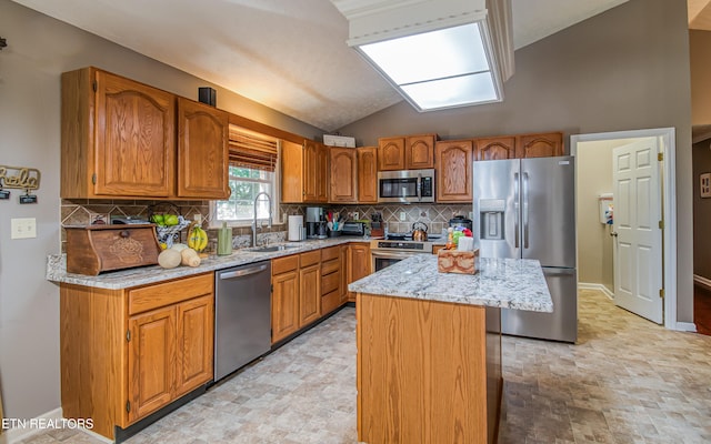 4512 Clairson Dr, Knoxville, TN 37931 - kitchen with stainless steel appliances, a sink, a kitchen island, light stone countertops, and tasteful backsplash