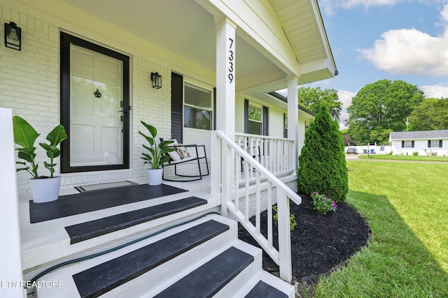7339 Brookside Dr, Chattanooga, TN 37421 - view of exterior entry featuring brick siding, covered porch, and a yard