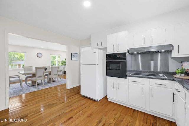 7339 Brookside Dr, Chattanooga, TN 37421 - kitchen with freestanding refrigerator, black oven, under cabinet range hood, electric cooktop, and light wood-style flooring
