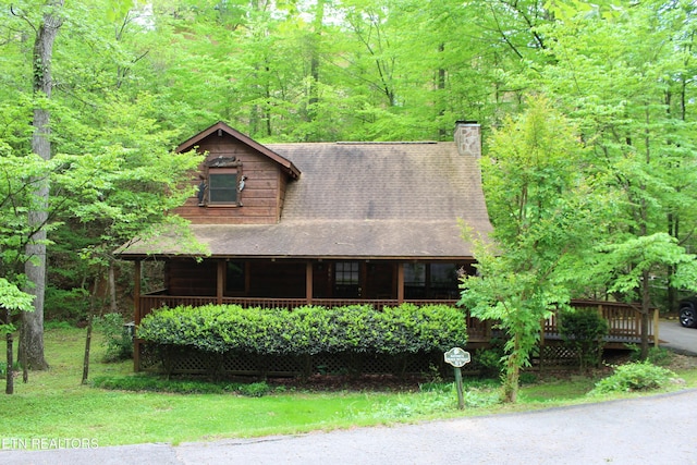 3006 Eagles Claw Way, Pigeon Forge, TN 37863 - view of front of home featuring a chimney, a shingled roof, covered porch, and a view of trees
