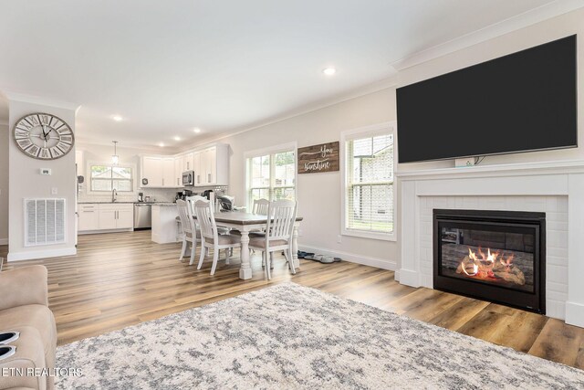 20 Cabot Ln, Cookeville, TN 38506 - dining room featuring ornamental molding, plenty of natural light, light wood-type flooring, recessed lighting, and a glass covered fireplace