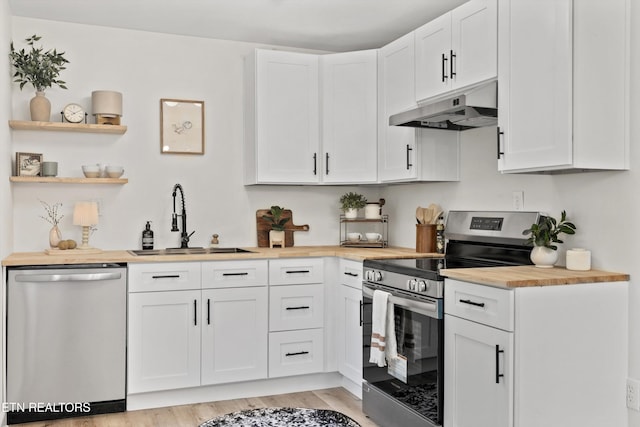 340 Gilbert St, Morristown, TN 37814 - kitchen with under cabinet range hood, stainless steel appliances, a sink, butcher block counters, and light wood-style floors