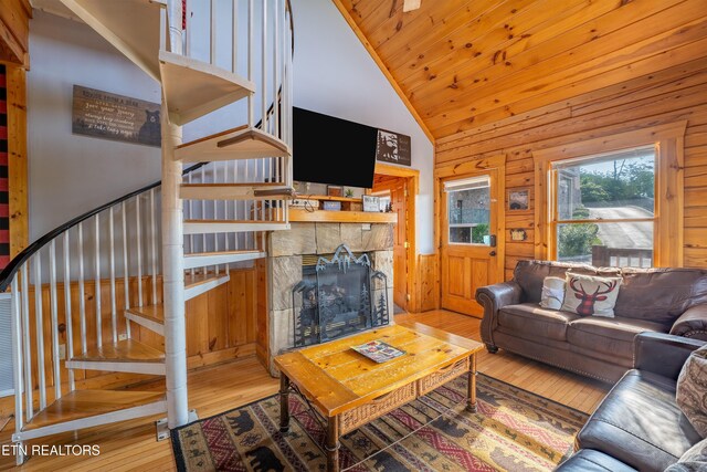 407 Big Bear Way, Pigeon Forge, TN 37863 - living room featuring stairway, hardwood / wood-style flooring, a stone fireplace, wooden walls, and high vaulted ceiling