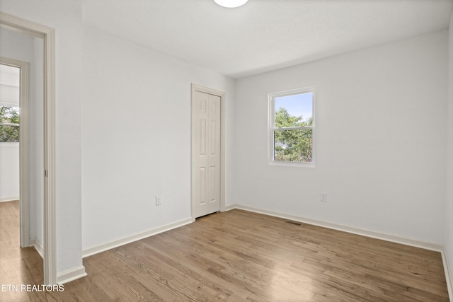 508 E Oldham Ave, Knoxville, TN 37917 - unfurnished bedroom with multiple windows, wood finished floors, and baseboards