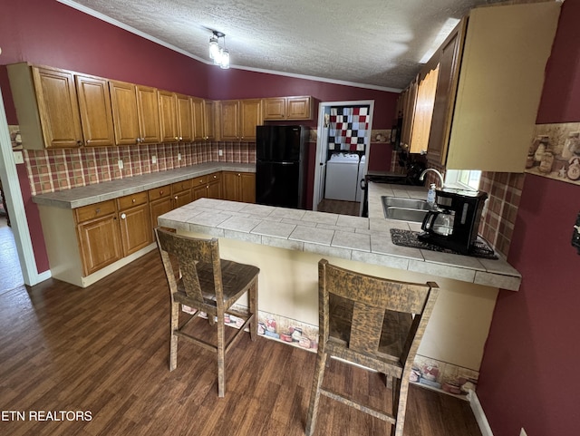 108 Hawn Dr, Crab Orchard, TN 37723 - kitchen featuring freestanding refrigerator, a sink, tile counters, washer / dryer, and a peninsula