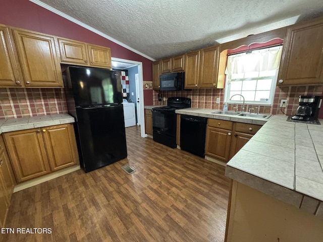 108 Hawn Dr, Crab Orchard, TN 37723 - kitchen featuring black appliances, a sink, tile counters, dark wood-style flooring, and vaulted ceiling
