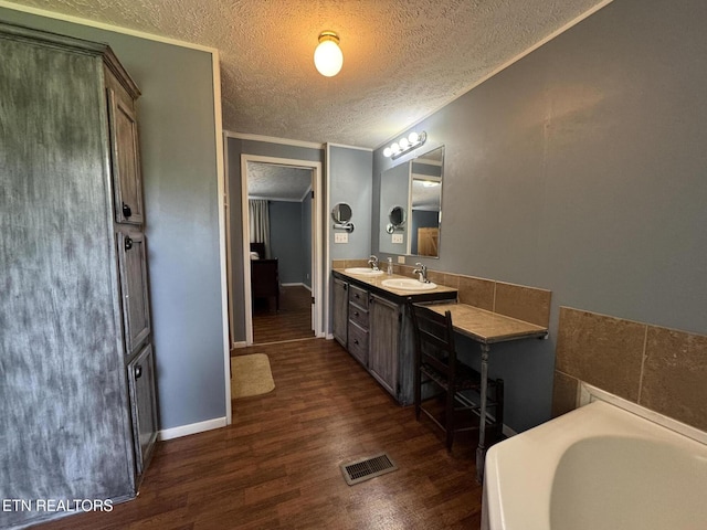 108 Hawn Dr, Crab Orchard, TN 37723 - full bath with a textured ceiling, vanity, a garden tub, wood finished floors, and baseboards