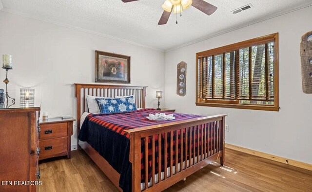 725 Sunshine Trl, Gatlinburg, TN 37738 - bedroom featuring wood finished floors, a textured ceiling, ornamental molding, and a ceiling fan