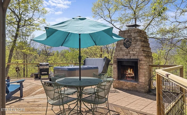 725 Sunshine Trl, Gatlinburg, TN 37738 - wooden terrace with an outdoor brick fireplace, a hot tub, outdoor dining area, a grill, and a patio area