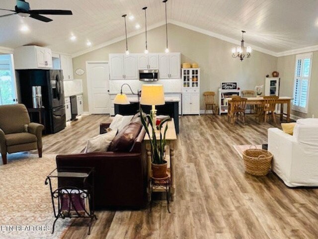 834 Hinkle Estates Dr, Seymour, TN 37865 - living room with light wood finished floors, a chandelier, a ceiling fan, vaulted ceiling, and crown molding