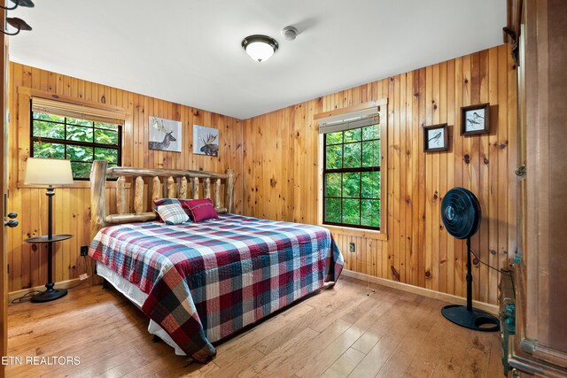 2295 Bluff Mountain Rd, Sevierville, TN 37876 - bedroom featuring wooden walls, wood-type flooring, and baseboards