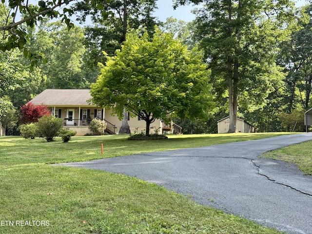406 Asheville Hwy, Strawberry Plains, TN 37871 - view of front of property with a porch, an outbuilding, a front yard, and driveway