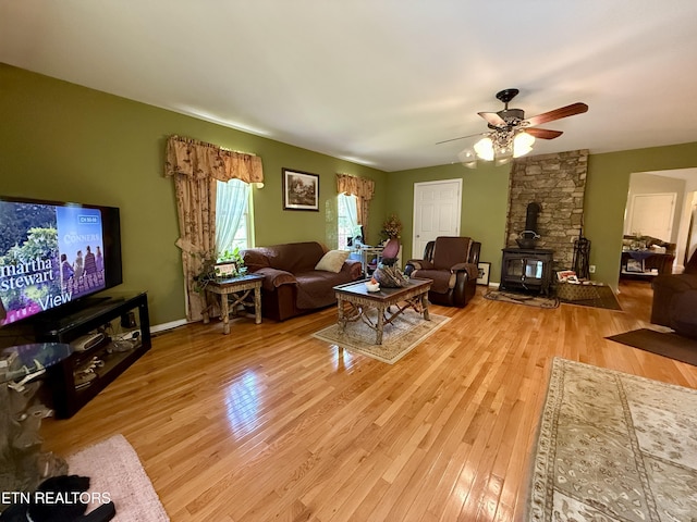 406 Asheville Hwy, Strawberry Plains, TN 37871 - living room with a wood stove, light wood-style flooring, and ceiling fan