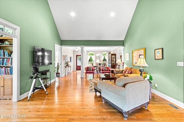 300 County Road 876, Englewood, TN 37329 - living area featuring a chandelier, high vaulted ceiling, light wood finished floors, ornate columns, and baseboards