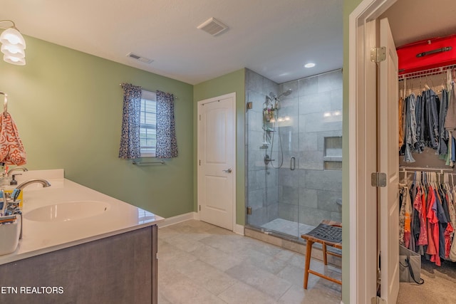 102 Deerberry Ln, Oak Ridge, TN 37830 - full bathroom featuring a walk in closet, a stall shower, double vanity, and tile patterned floors