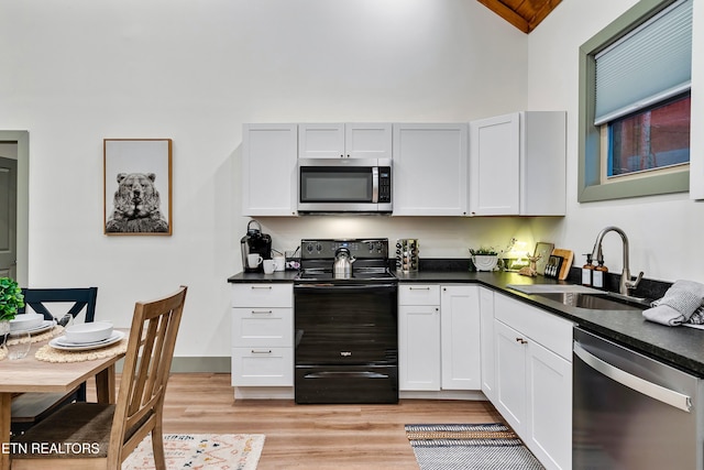 1719 Walker Trl, Sevierville, TN 37876 - kitchen featuring appliances with stainless steel finishes, a sink, dark countertops, and high vaulted ceiling