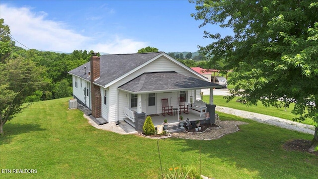 245 Lake Shore Ln, Lafollette, TN 37766 - view of front of house featuring a chimney, roof with shingles, a porch, and a front yard