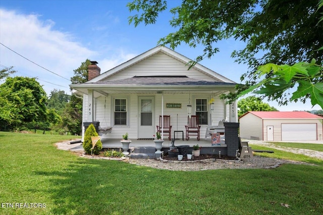 245 Lake Shore Ln, Lafollette, TN 37766 - view of front facade featuring a porch, a detached garage, a front lawn, a chimney, and an outbuilding