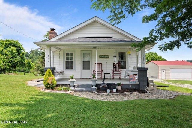 245 Lake Shore Ln, Lafollette, TN 37766 - view of front facade with a porch, a front yard, a chimney, an outdoor structure, and a detached garage