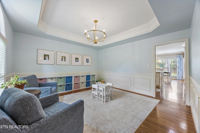 11919 Burnside Pl, Knoxville, TN 37934 - living room featuring crown molding, a chandelier, wood finished floors, wainscoting, and a raised ceiling