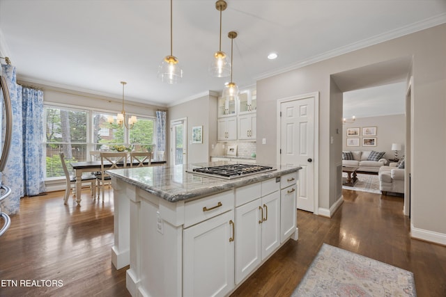 11919 Burnside Pl, Knoxville, TN 37934 - kitchen with a chandelier, stainless steel gas cooktop, dark wood finished floors, white cabinetry, and ornamental molding