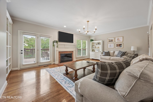 11919 Burnside Pl, Knoxville, TN 37934 - living area featuring healthy amount of natural light, a chandelier, ornamental molding, wood finished floors, and baseboards