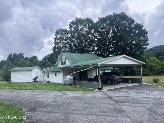 151 Davis Rd, Sneedville, TN 37869 - view of front of property with driveway, a front yard, metal roof, and an outbuilding