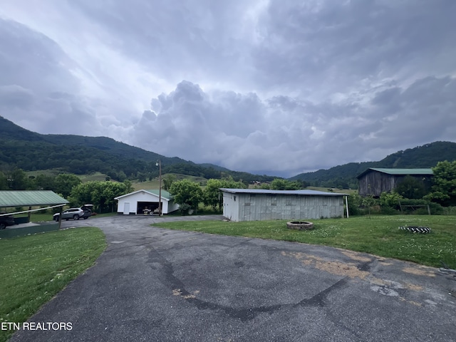 151 Davis Rd, Sneedville, TN 37869 - view of side of property with a mountain view, a lawn, an outbuilding, and a garage