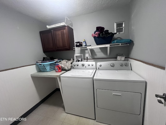 151 Davis Rd, Sneedville, TN 37869 - laundry room with washing machine and dryer, cabinet space, a textured ceiling, and light tile patterned flooring