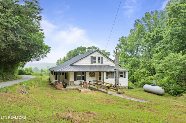 138 Bethlehem Ln, Lafollette, TN 37766 - rear view of house featuring a porch, a chimney, a yard, and metal roof
