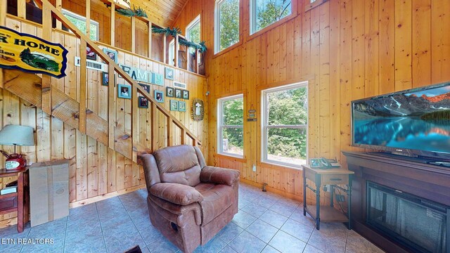 1464 Blue Mill Rd, Del Rio, TN 37727 - living room featuring wood walls, high vaulted ceiling, baseboards, and tile patterned flooring