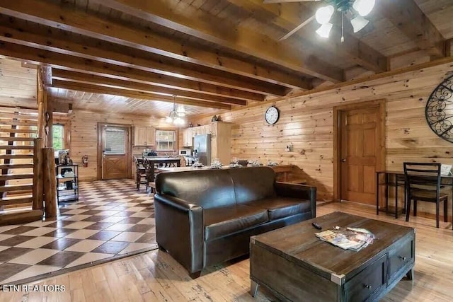 1056 Black Bear Cub Way, Sevierville, TN 37862 - living area with wood walls, wood ceiling with exposed beams, a ceiling fan, and light flooring