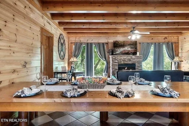 1056 Black Bear Cub Way, Sevierville, TN 37862 - tiled living room featuring wooden walls, a stone fireplace, beamed ceiling, and a ceiling fan