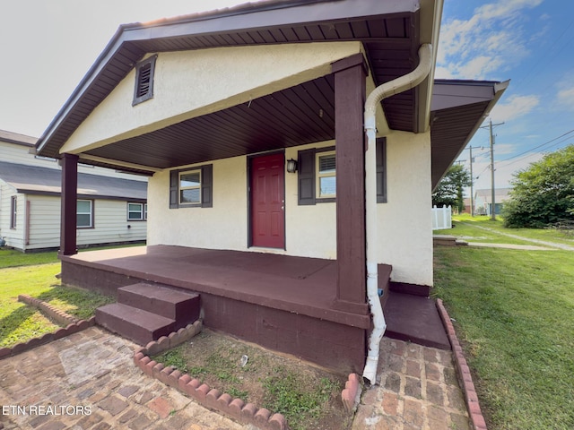 104 Church St, Loudon, TN 37774 - view of front of house featuring covered porch, stucco siding, and a front lawn