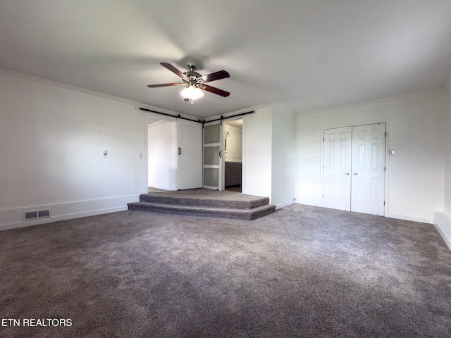 104 Church St, Loudon, TN 37774 - unfurnished bedroom featuring a barn door, carpet flooring, ceiling fan, and two closets