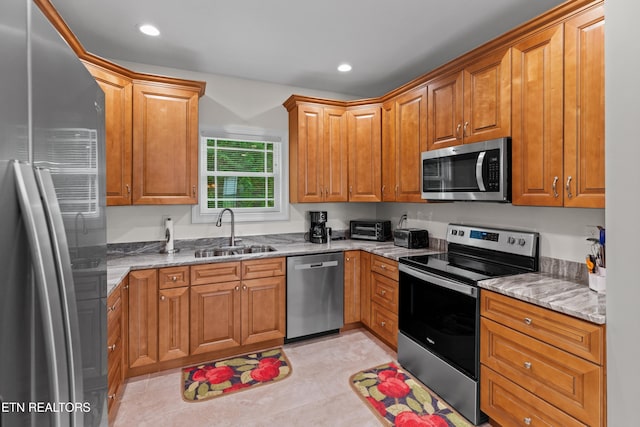 4153 Harbor View Dr, Morristown, TN 37814 - kitchen with appliances with stainless steel finishes, a sink, light stone counters, recessed lighting, and brown cabinets