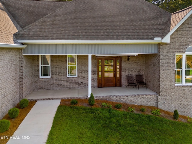 4153 Harbor View Dr, Morristown, TN 37814 - doorway to property featuring a shingled roof, brick siding, covered porch, and a yard