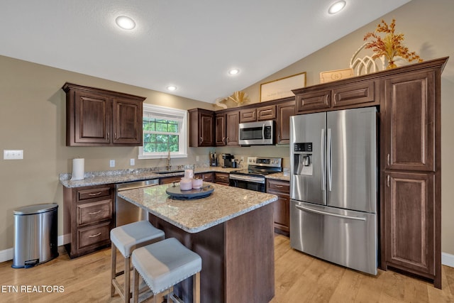 142 Breezy Ln, New Tazewell, TN 37825 - kitchen with appliances with stainless steel finishes, a kitchen breakfast bar, a sink, vaulted ceiling, and dark brown cabinets