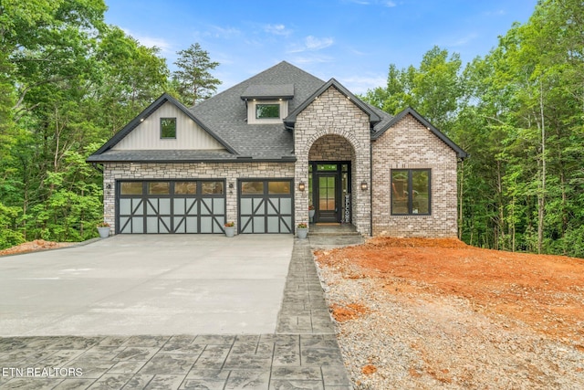104 Noya Ln, Loudon, TN 37774 - view of front facade featuring driveway, an attached garage, a shingled roof, stone siding, and brick siding