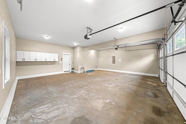 104 Noya Ln, Loudon, TN 37774 - garage featuring a garage door opener, baseboards, and electric panel