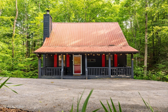 391 Laurel Rd, Townsend, TN 37882 - view of front of property featuring a porch, a chimney, metal roof, and a wooded view