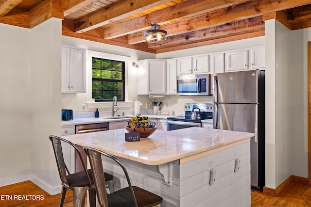 391 Laurel Rd, Townsend, TN 37882 - kitchen featuring stainless steel appliances, a sink, baseboards, white cabinets, and wooden ceiling with exposed beams